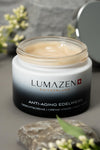 Open jar of Lumazen Anti-Aging Edelweiss Day Cream showing the soft beige cream, on stone with alpine flowers