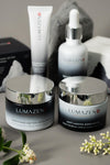 The Complete Alpine Ritual set: all four Lumazen Edelweiss products, day cream, night cream, eye cream and hair tonic, on grey stone